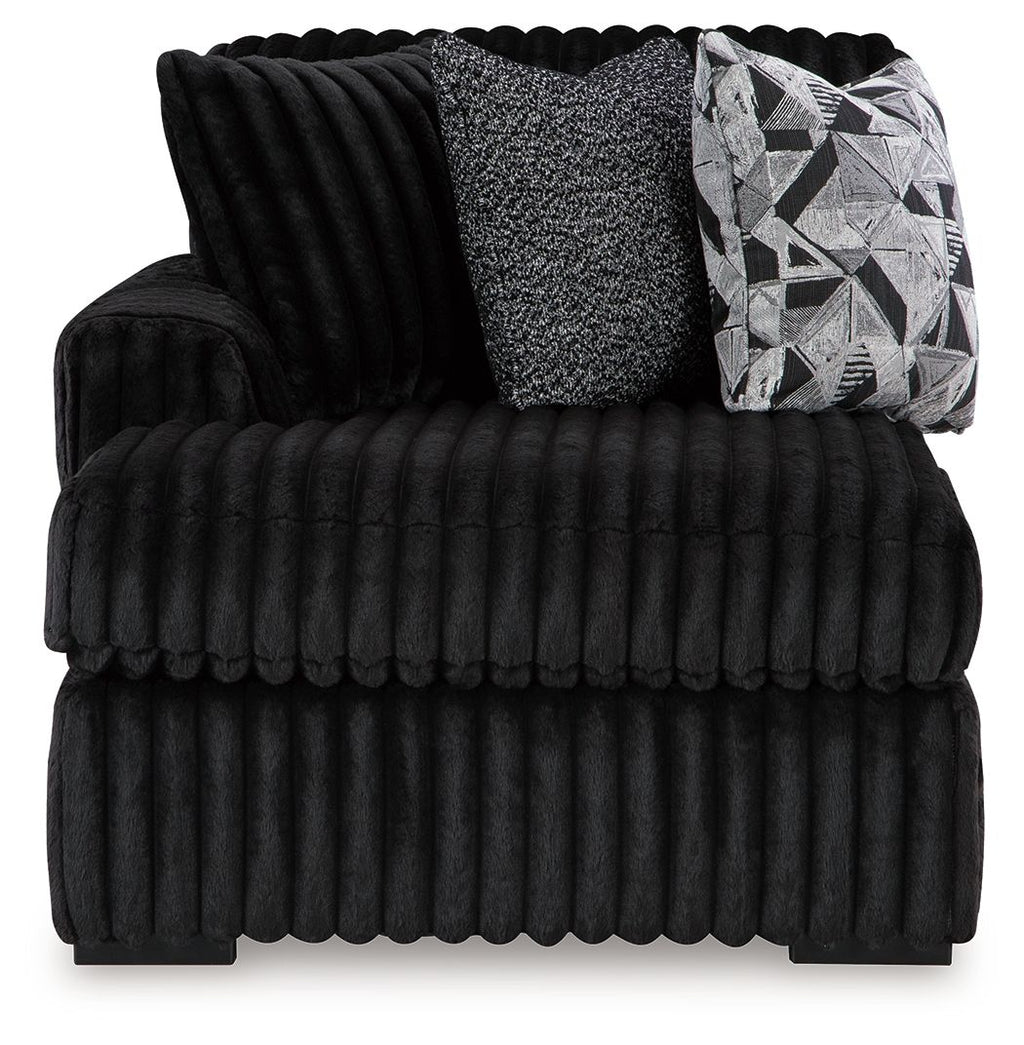 Onyx corner chaise with deep tufted ribbed cushions and geometric throw pillow