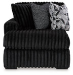 Onyx corner chaise with deep tufted ribbed cushions and geometric throw pillow