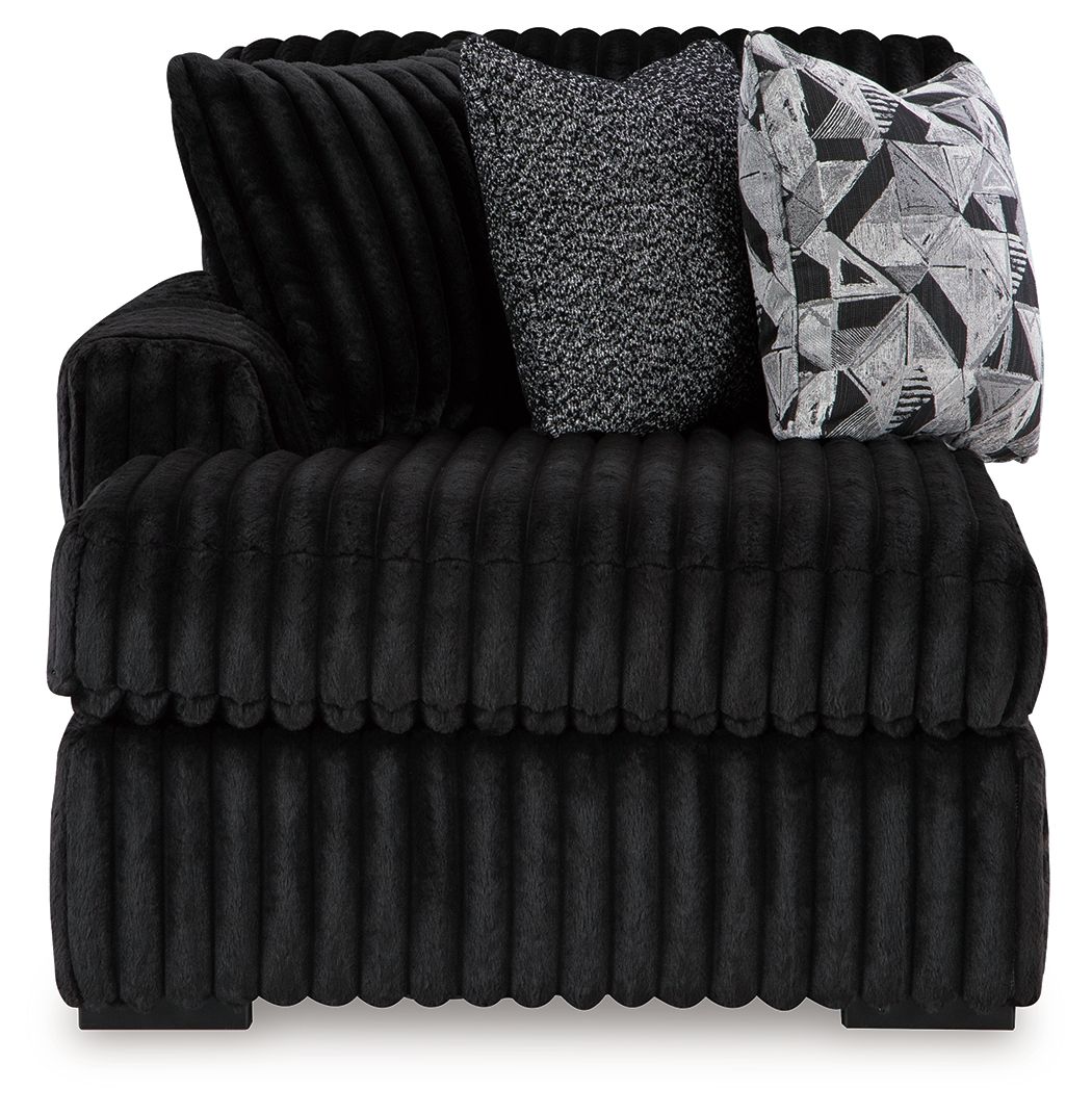 Onyx corner chaise with deep tufted ribbed cushions and geometric throw pillow