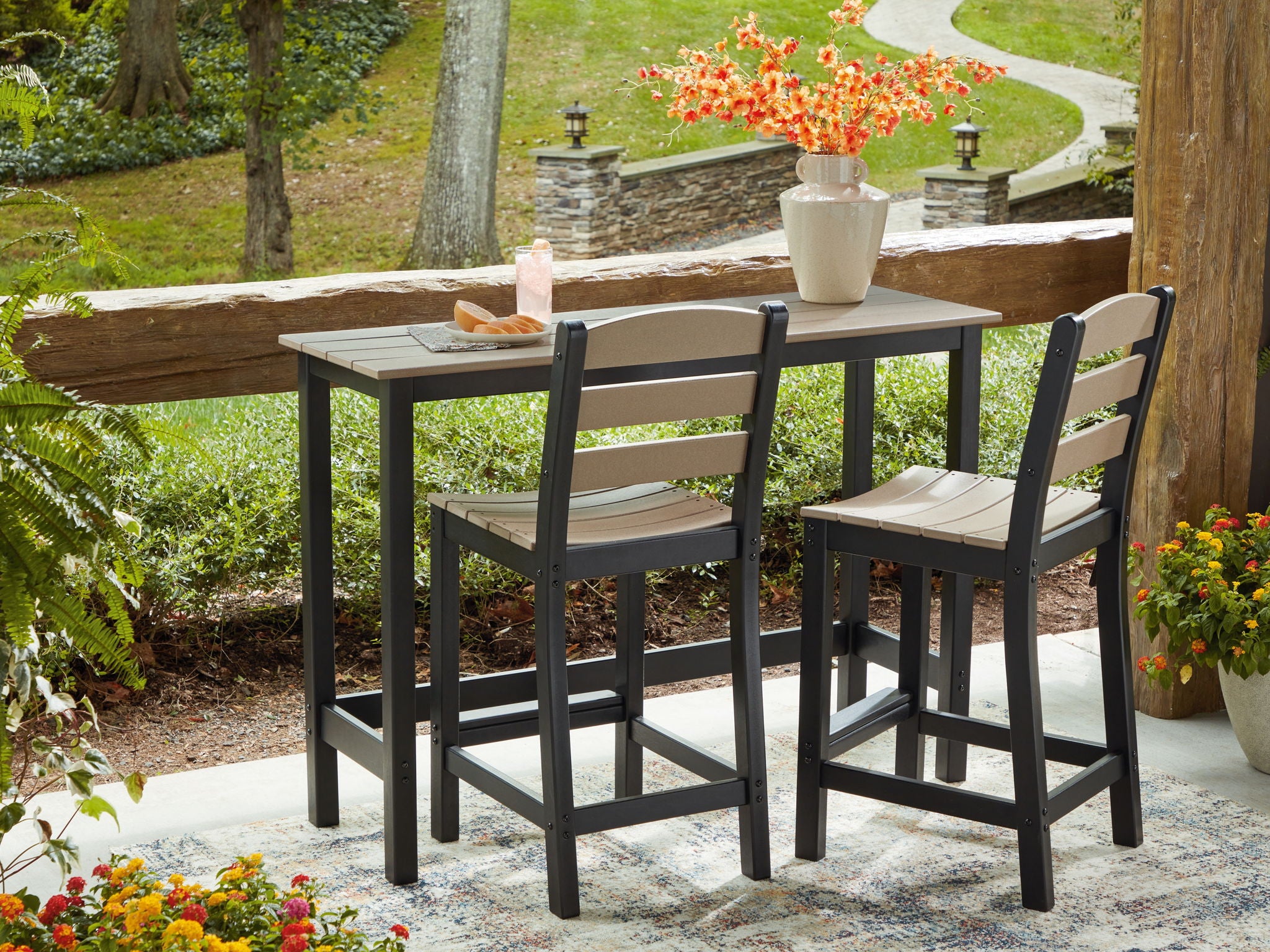 Outdoor counter table with 2 barstools, black frames and beige cushions