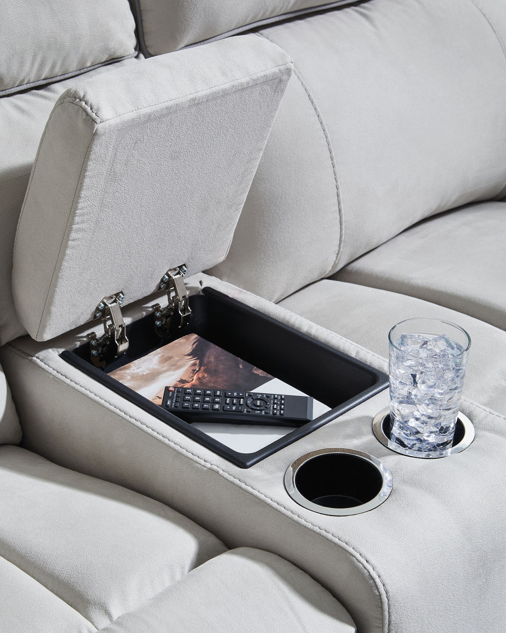 Recliner console with cup holder and storage tray on light gray sofa arm