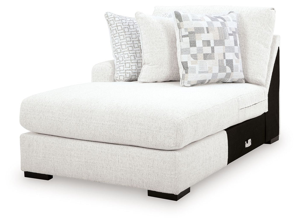Chalk corner chaise with padded arm, deep seat, and two patterned throw pillows