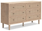 Beige wood dresser with six drawers and black pulls, side panel detail