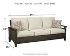 Medium brown wicker sofa with beige cushions and two patterned throw pillows, 85 in width