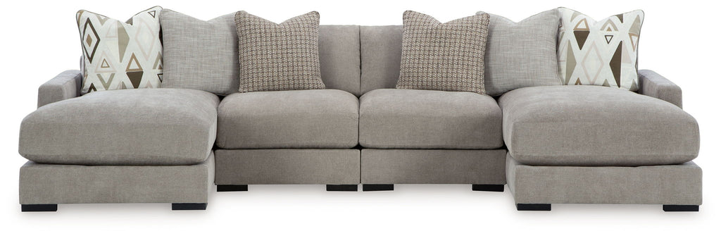 Gray sectional sofa with three ottoman-style seats and decorative patterned throw pillows