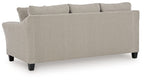 Taupe upholstered sofa with tufted seat cushions, back pillows, dark legs