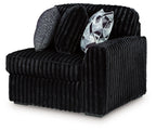 Onyx corduroy corner chair with ribbed upholstery and geometric throw pillow