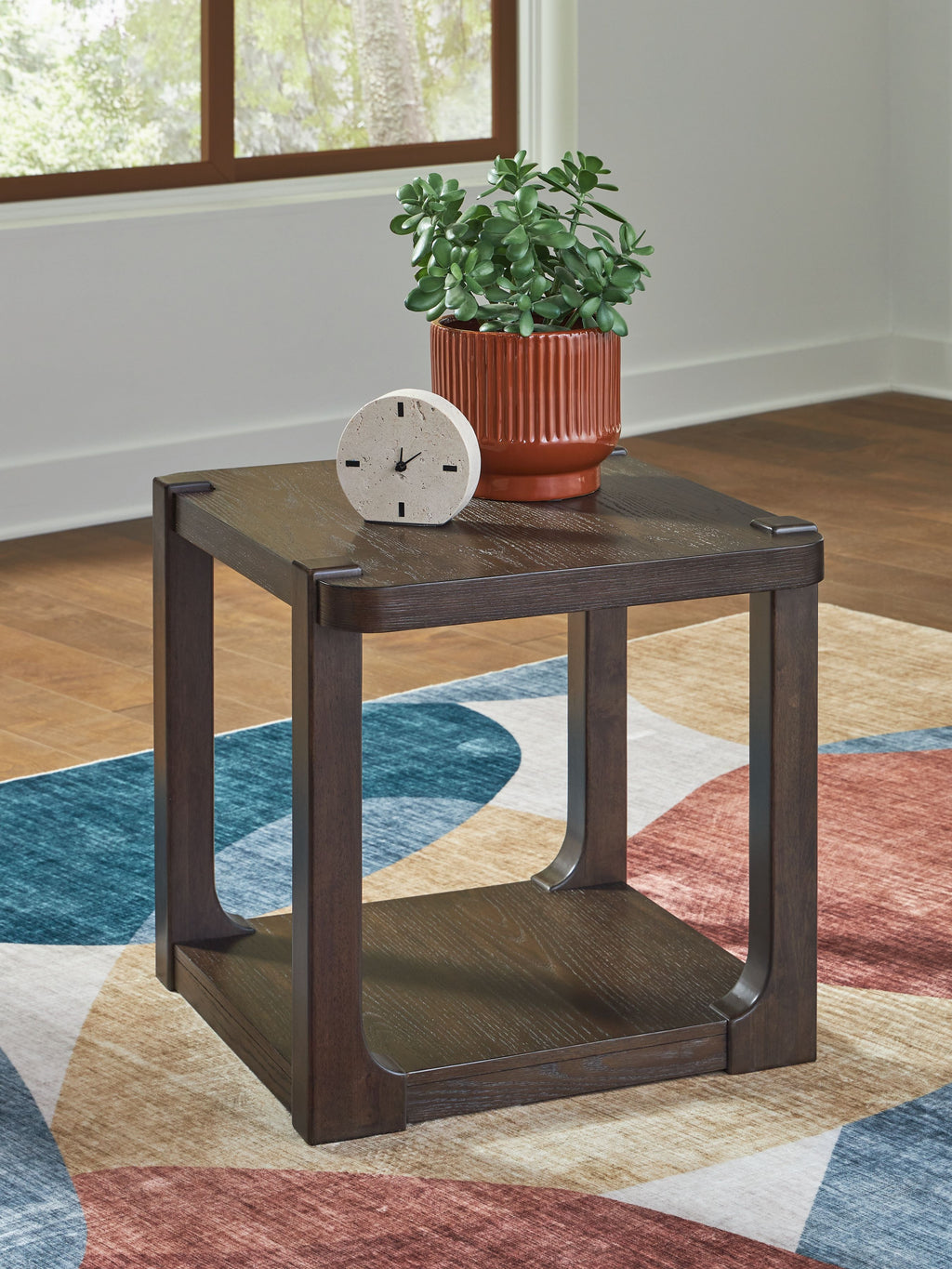 Dark brown two-tier table with open lower shelf; decor items on top