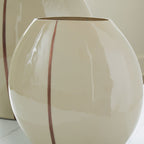 Beige ceramic vase close view with glossy finish and vertical brown stripe