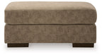 Dark brown fabric ottoman with padded top and dark wooden legs.