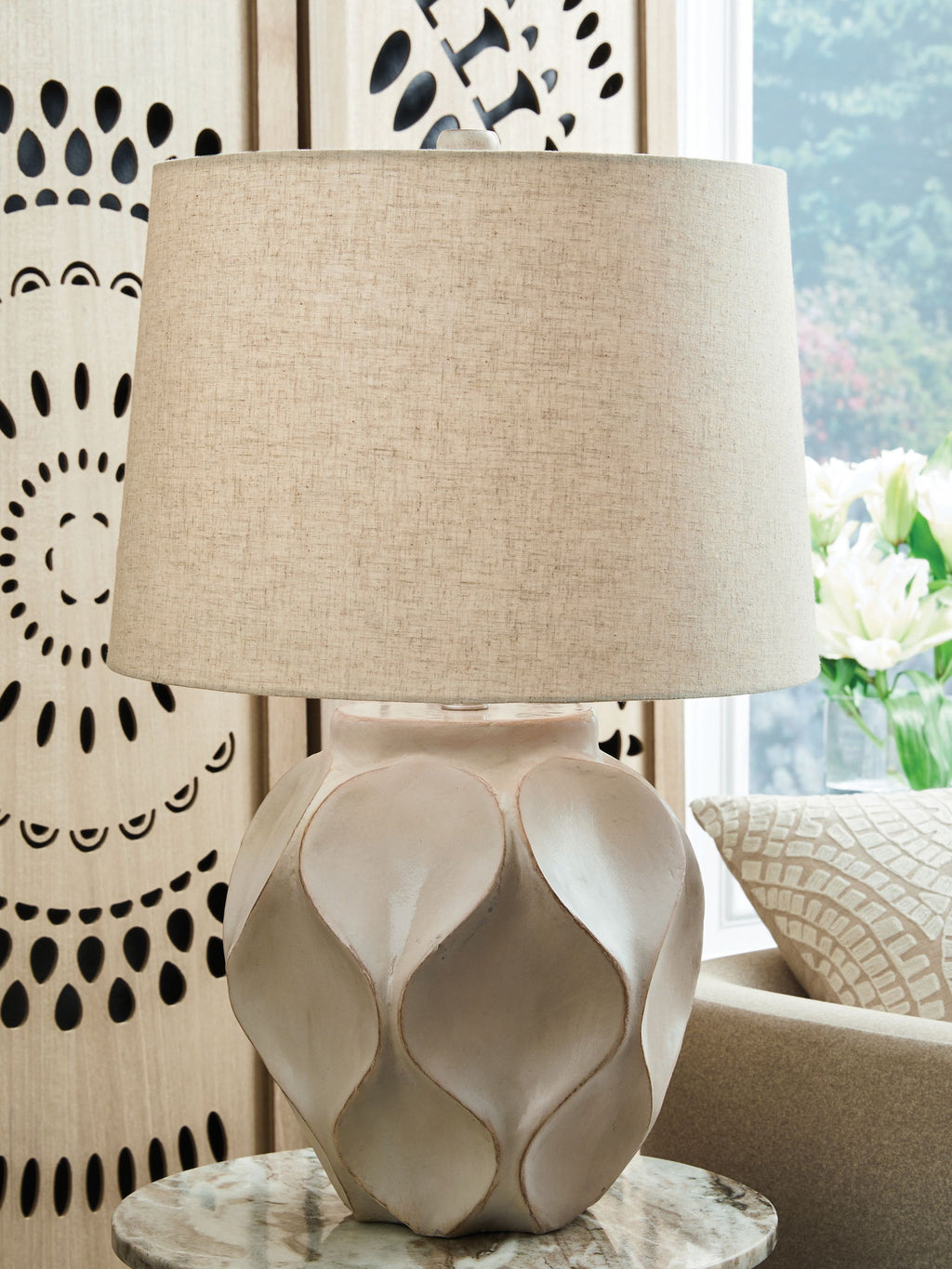 Distressed cream paper table lamp with drum shade and carved faceted base