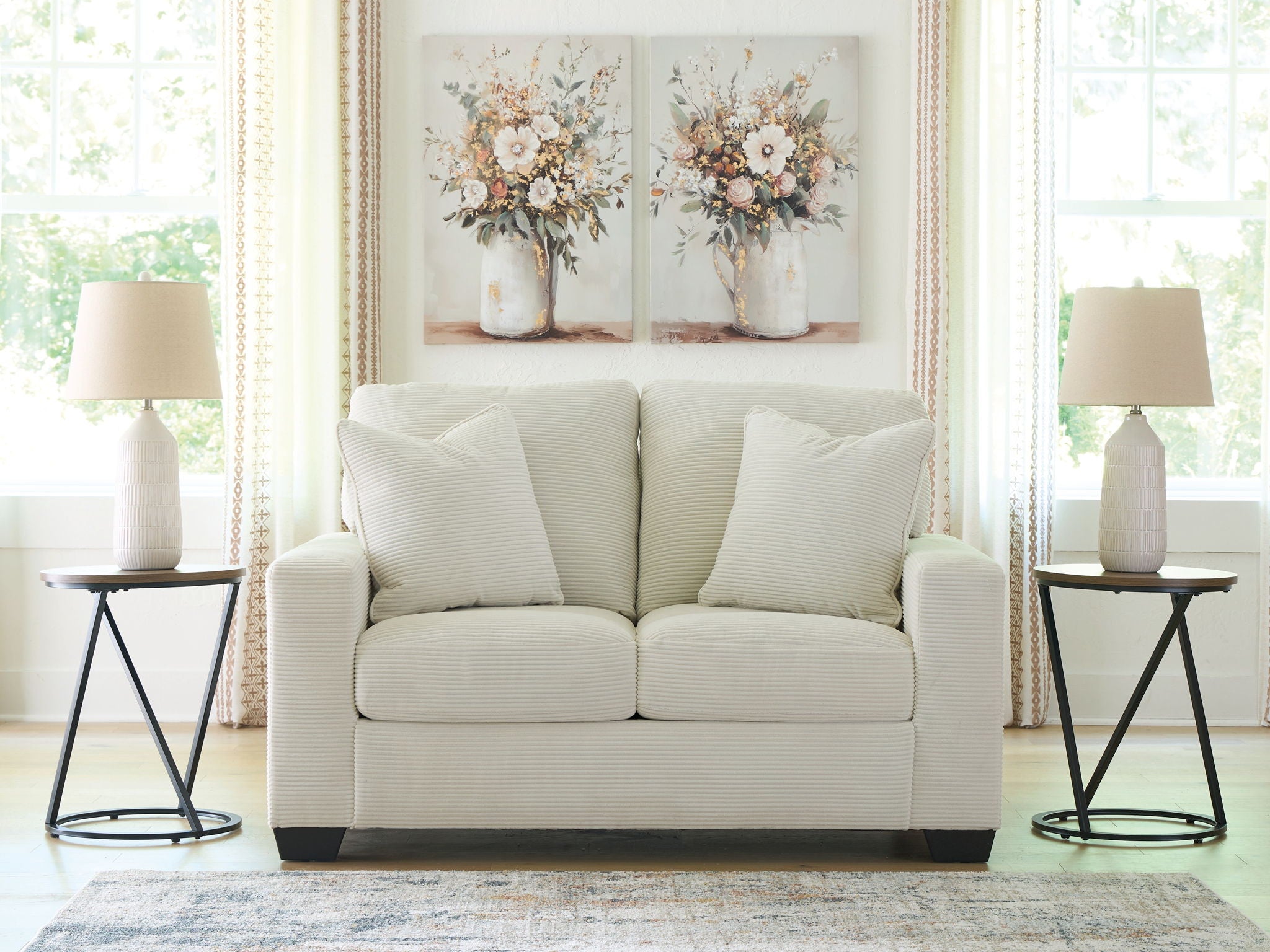 Upholstered loveseat with two seat cushions and three throw pillows, light upholstery