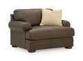 Dark brown chair with rolled arms and two patterned throw pillows