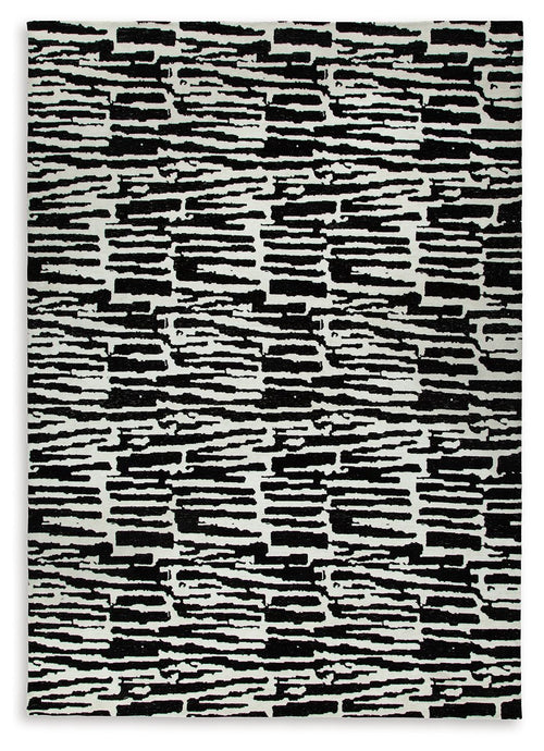 Black-and-white abstract striped area rug with irregular blocks and high-contrast lines