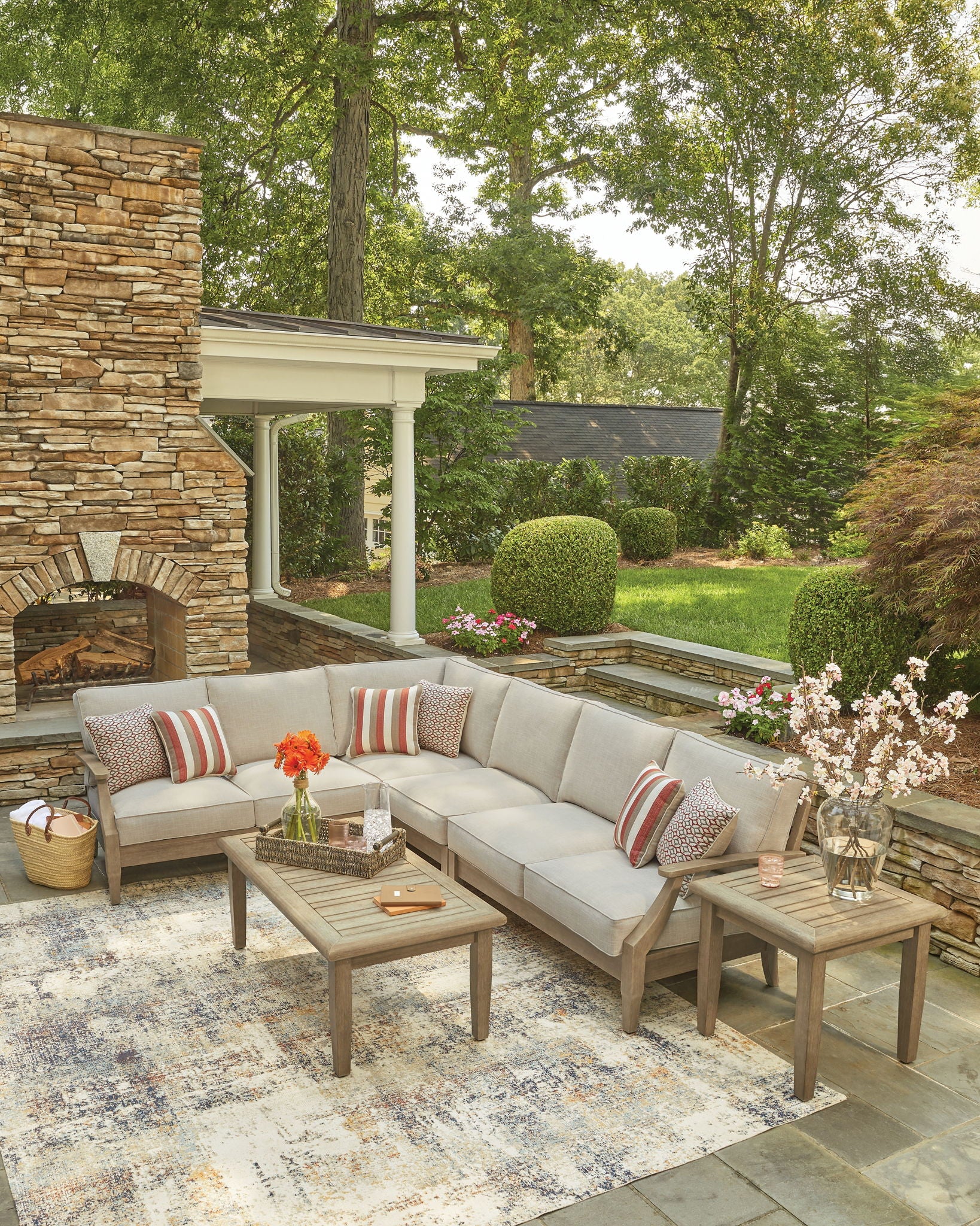 Beige outdoor sectional sofa with striped pillows and patterned accent cushions
