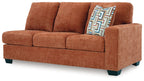 Rust orange RAF sofa side view with armrest and patterned cushion