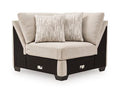 Beige upholstered wedge chair with two throw pillows and dark wooden base