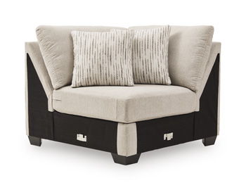 Beige upholstered wedge chair with two throw pillows and dark wooden base