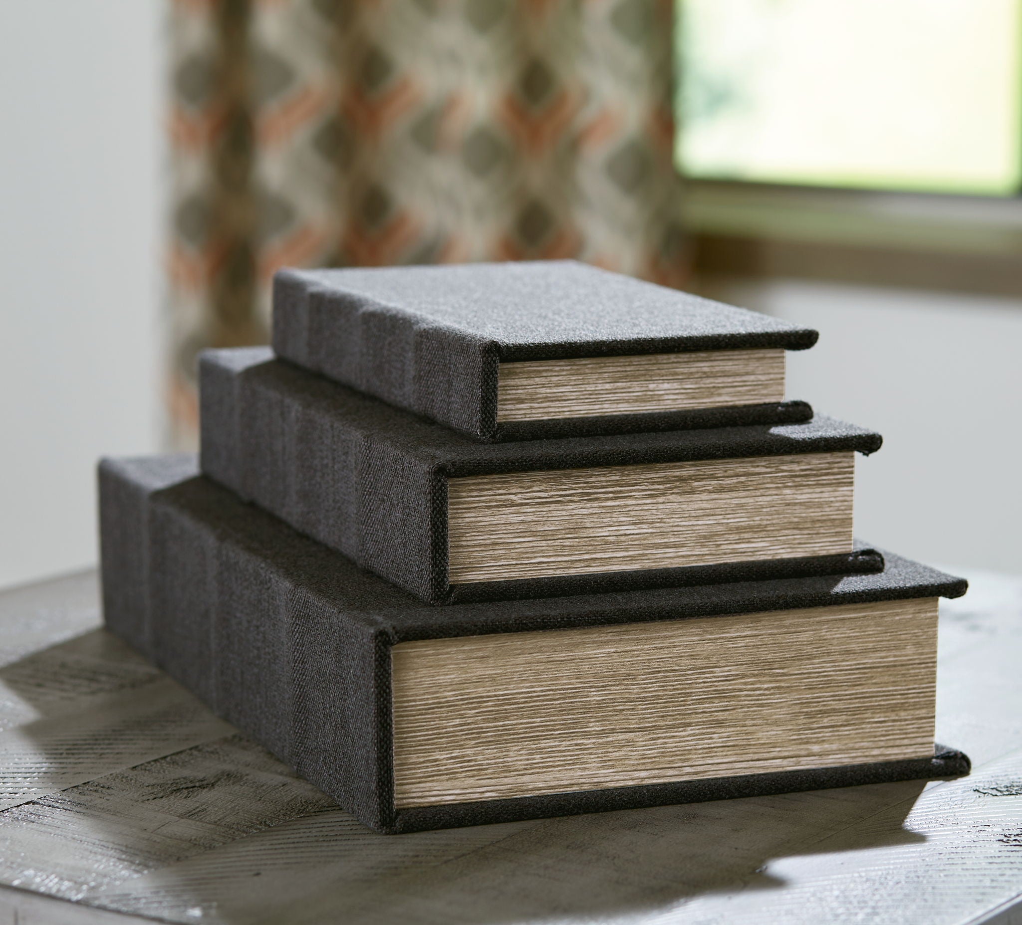 Decorative box set with stacked dark gray fabric lids and wood-textured sides.