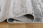 Gray area rug edge with stitched border and low pile