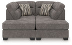 Dark gray sectional sofa with two chaise ottoman sections and two striped accent pillows
