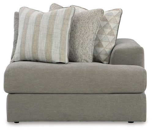 Ash gray corner chair with thick seat, armrests, and four decorative pillows