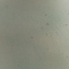 Green ceramic vase surface with mottled speckle pattern
