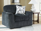 Dark gray chair and a half with geometric pillow and cushioned backrest