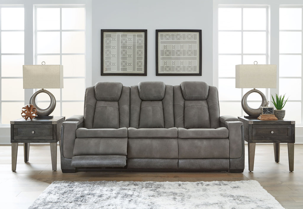 Slate power reclining sofa with tufted seat cushions, padded headrests, and recline backs.