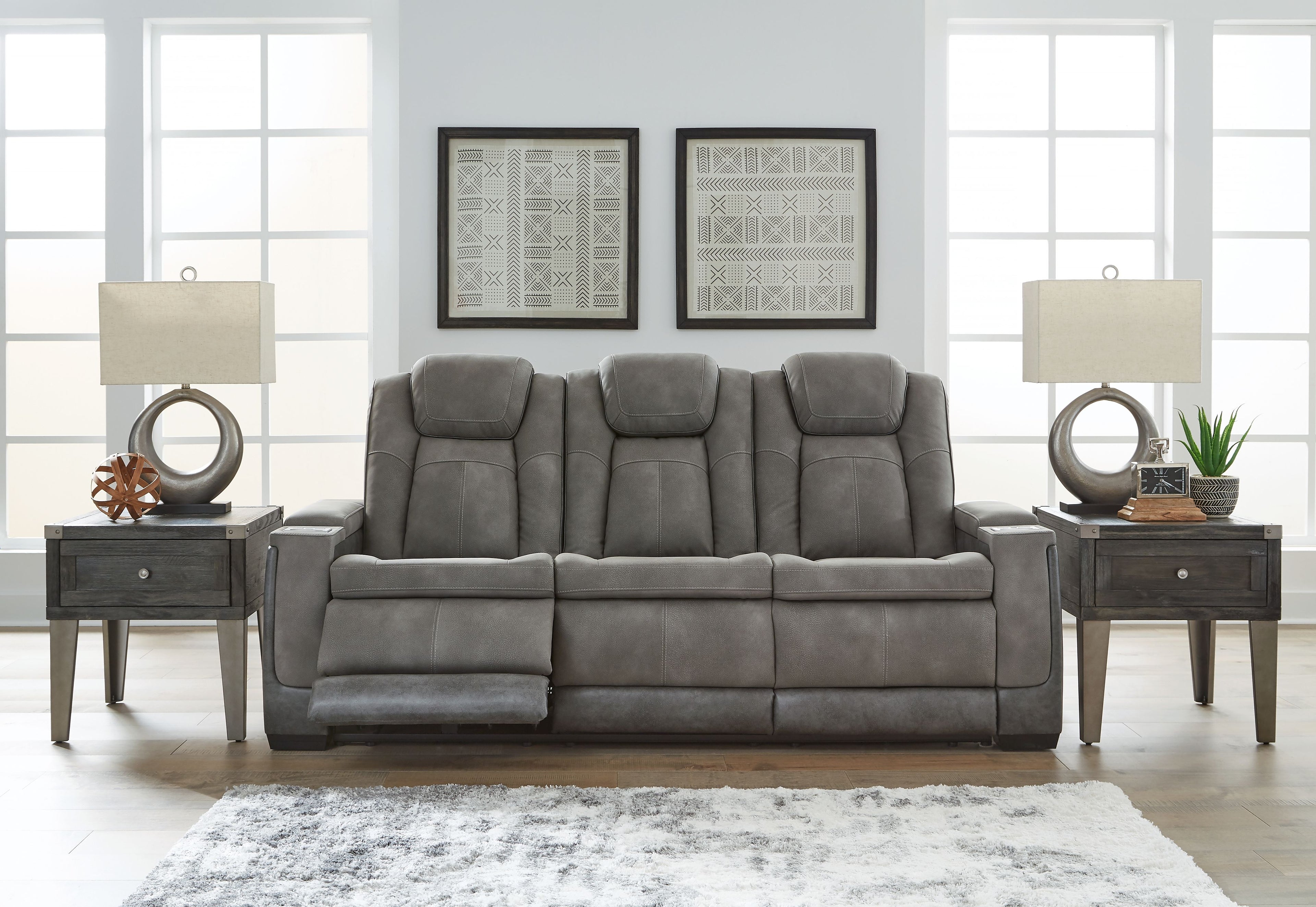 Slate power reclining sofa with tufted seat cushions, padded headrests, and recline backs.
