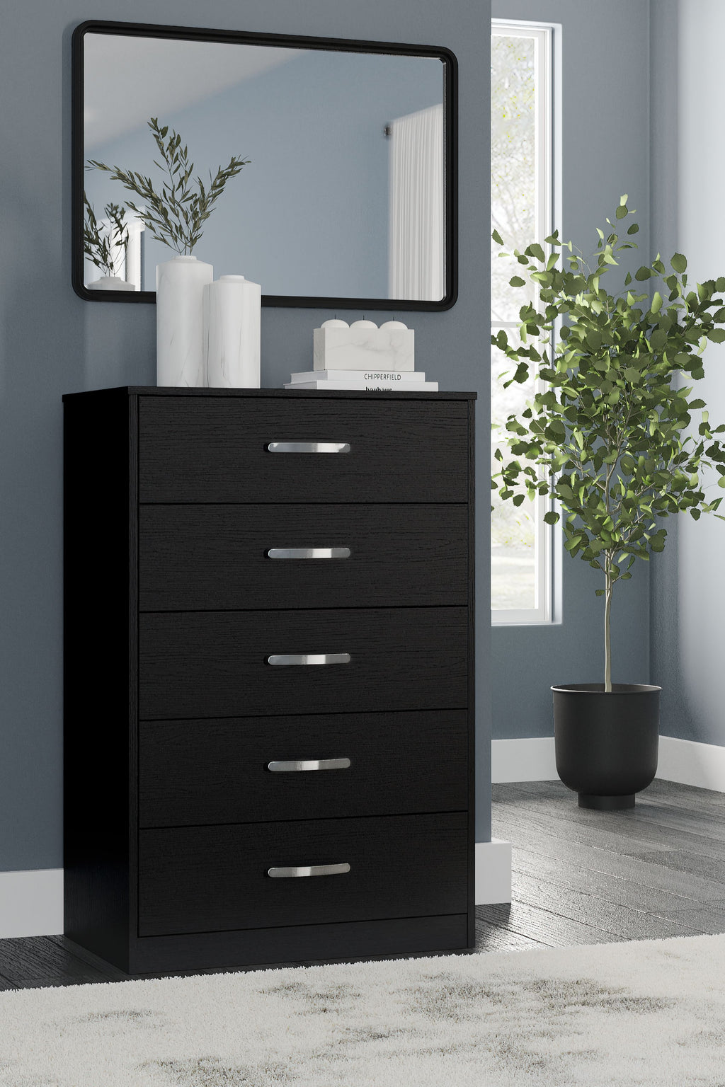 Black five-drawer chest with silver bar pulls and mirror panel on top.