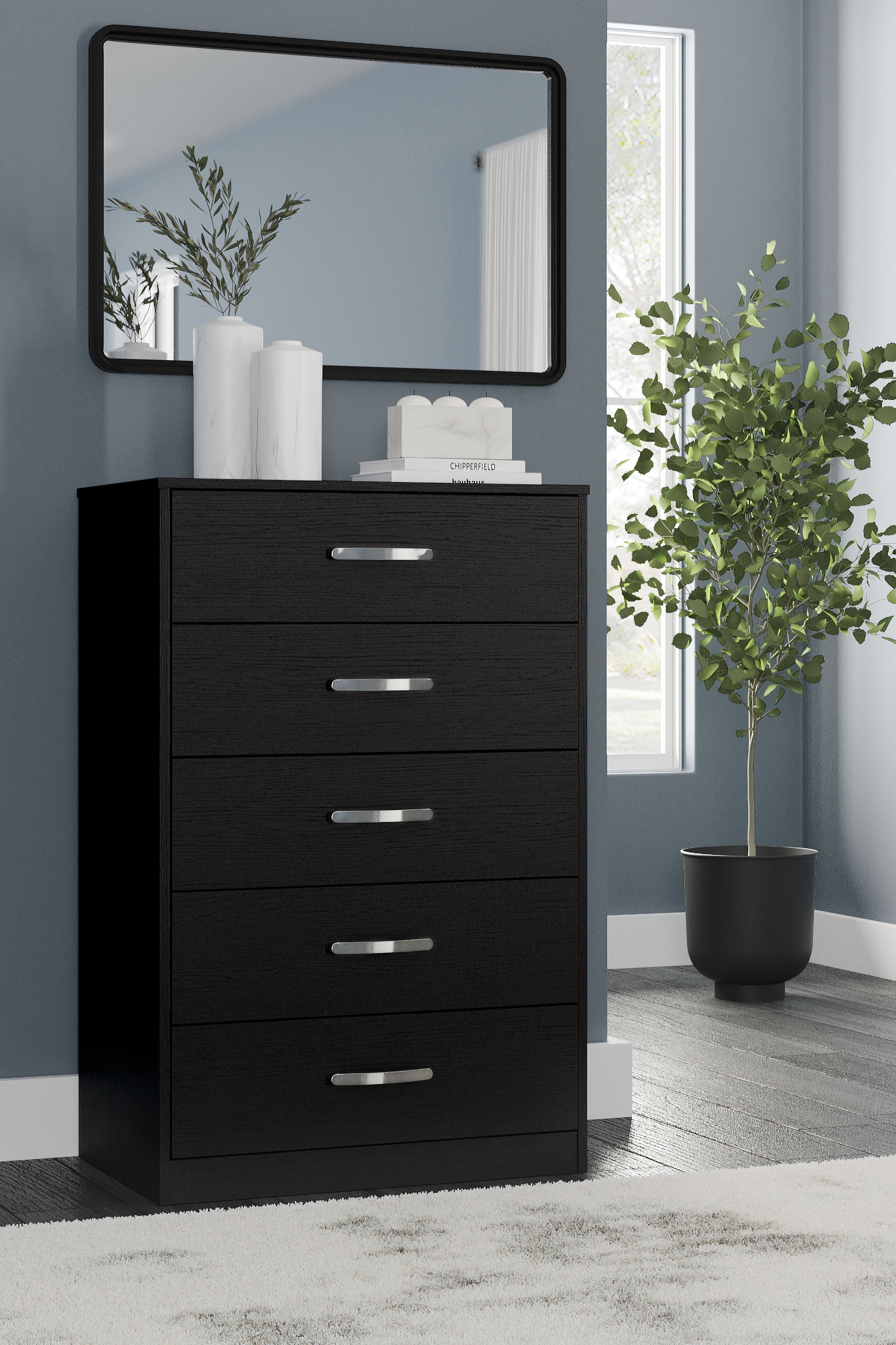 Black five-drawer chest with silver bar pulls and mirror panel on top.
