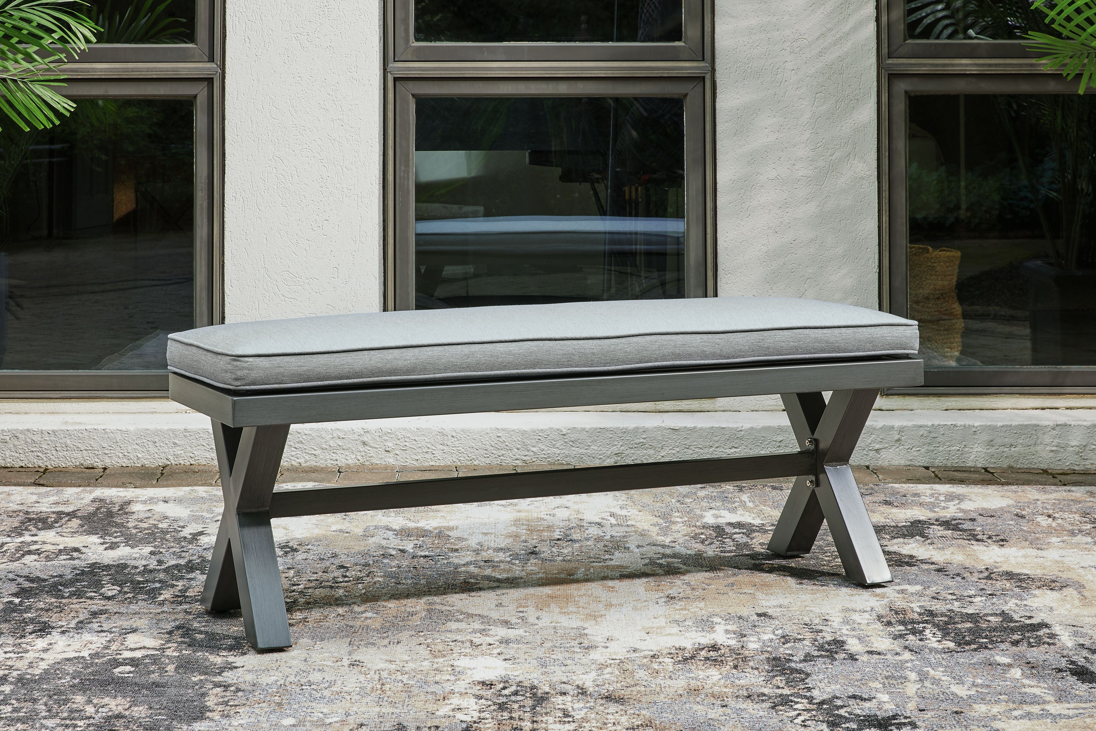 Gray outdoor bench with cushion and angled dark gray supports