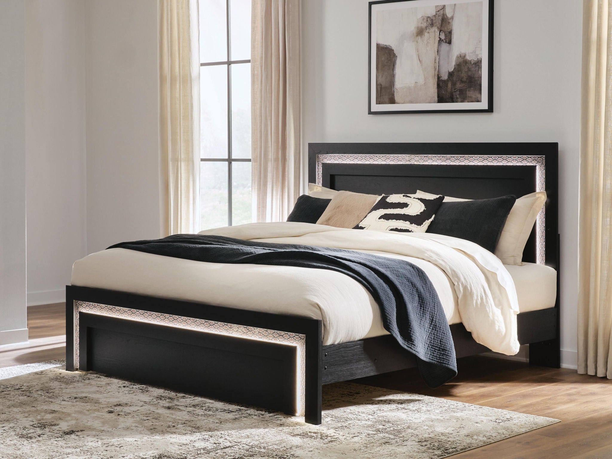 Black panel bed with tall headboard and low footboard, decorative edge trim, bedding