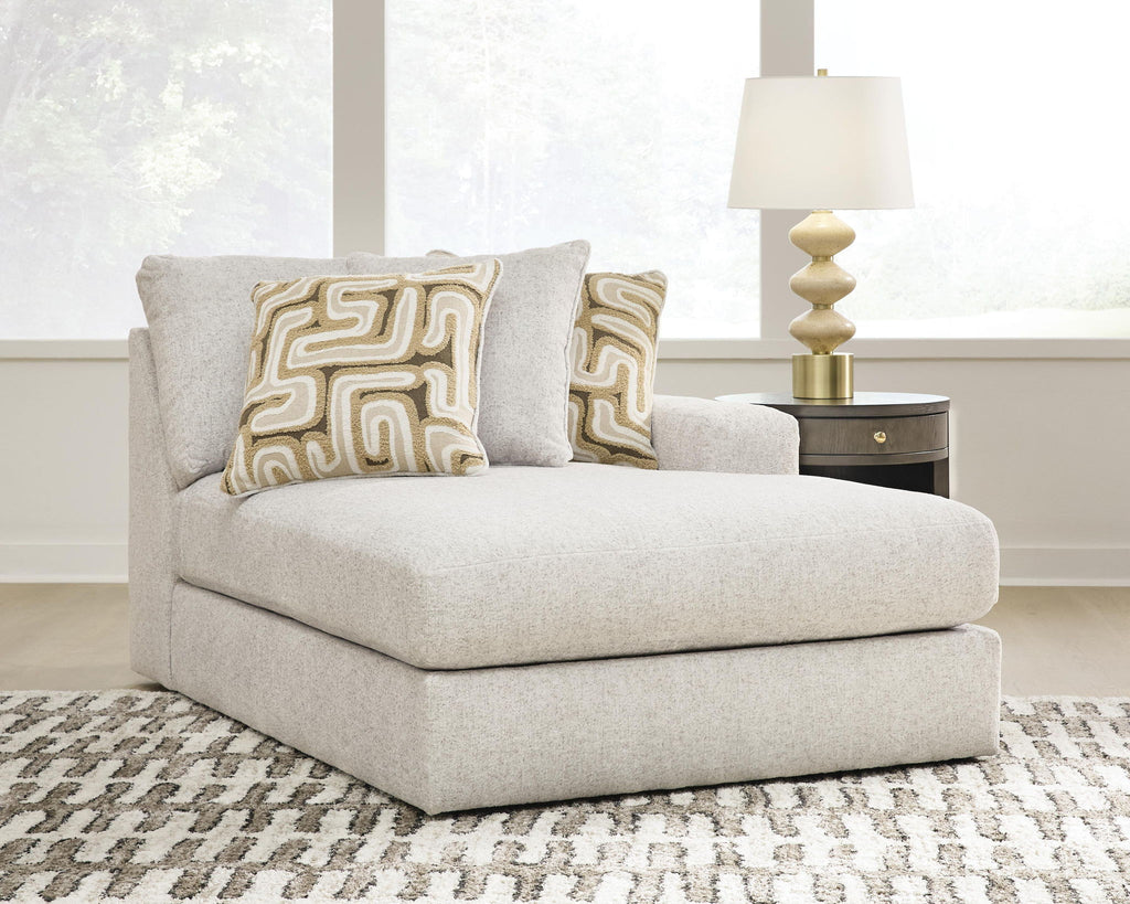 Light beige corner chaise with two patterned cushions and a wide rounded arm