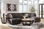 Dark charcoal fabric sectional sofa with chaise, two corner cushions, and three decorative pillows