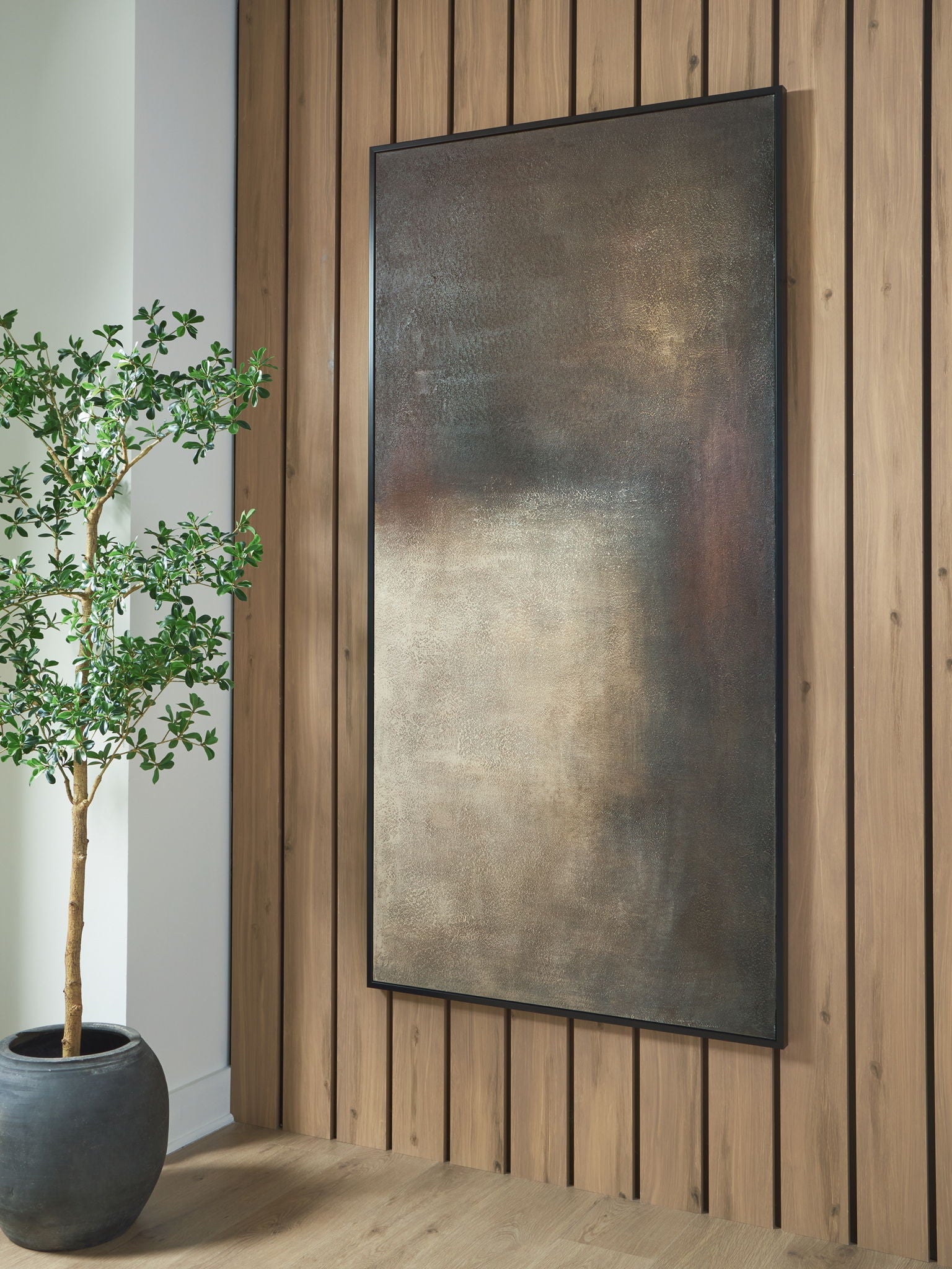 Abstract rectangular wall art with dark gray, rust, and cream texture, hanging on wall