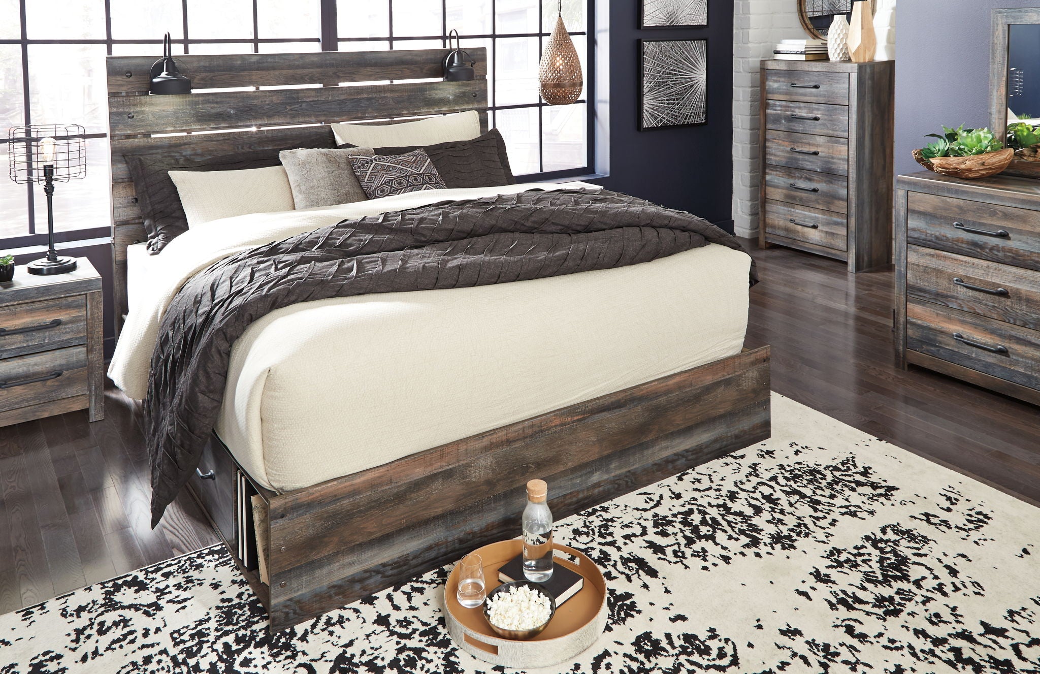 Panel bed with dark wood frame and panel headboard; beige and gray bedding with throw blankets