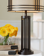 Dark brown metal table lamp with beige drum shade and vertical bar frame