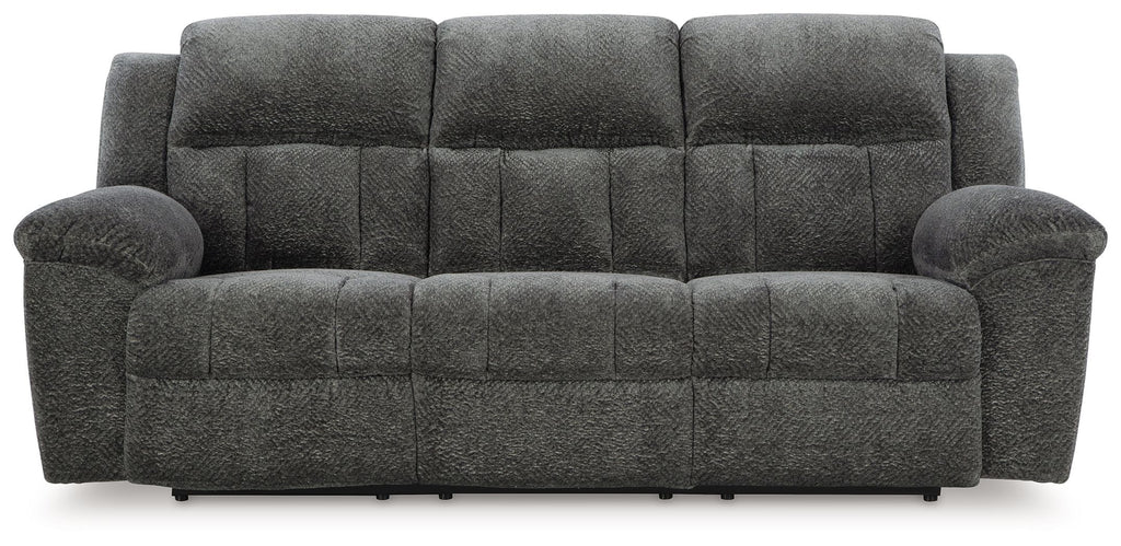 Graphite gray reclining sofa with tufted seat and back, padded rounded arms, and legs