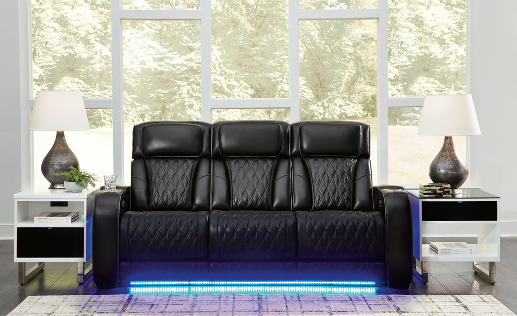 Black power reclining sofa with quilted upholstery and wide armrest panels