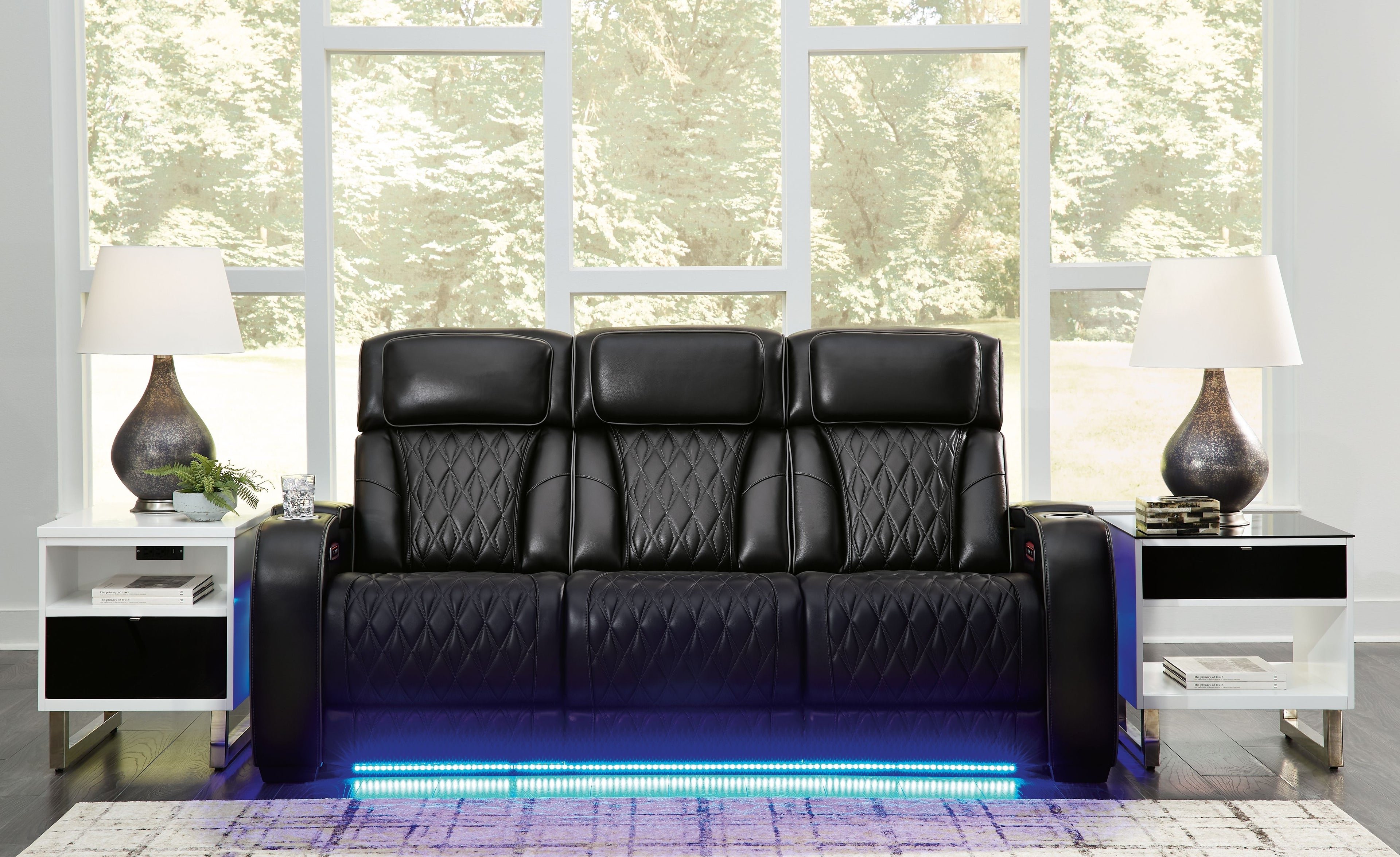 Black power reclining sofa with quilted upholstery and wide armrest panels