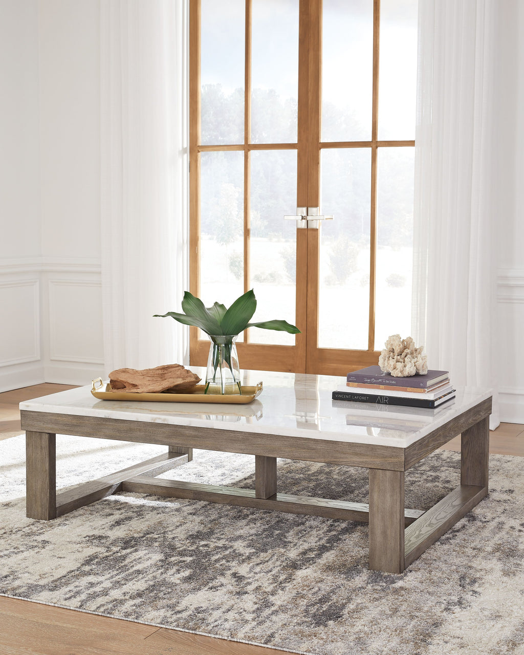 Rectangular cocktail table with white marble-look surface and brown wood base.