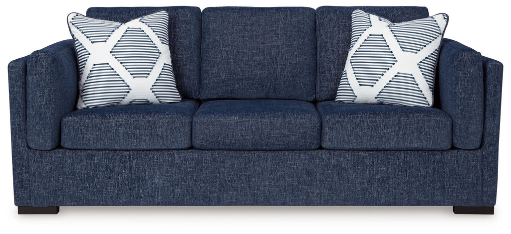 Navy fabric sofa with two patterned throw pillows and three seat cushions
