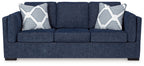 Navy fabric sofa with two patterned throw pillows and three seat cushions