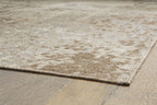 Light brown rug corner with stitched edge and low, plush texture