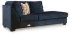 Ink blue corner chaise sofa with left armrest, patterned pillow, and dark feet