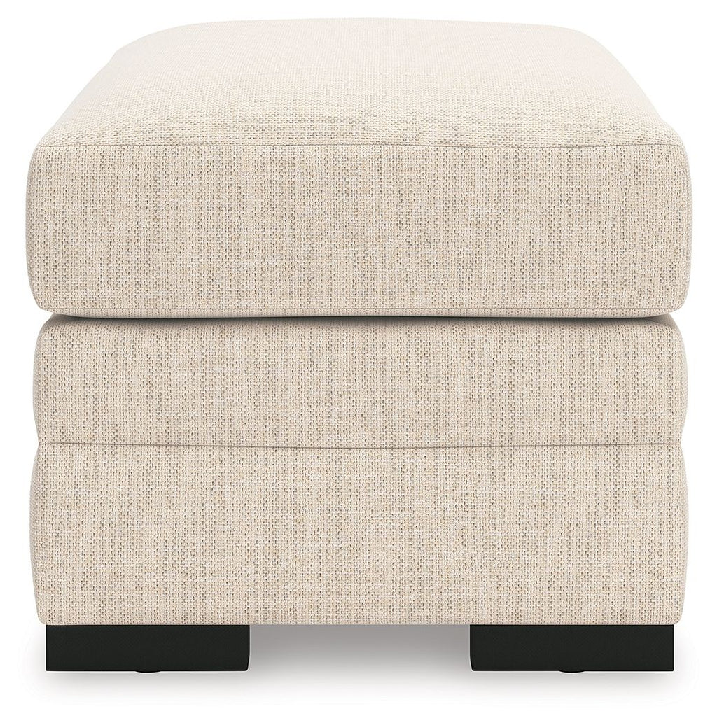 Light beige rectangular ottoman with cushioned lid and black block feet