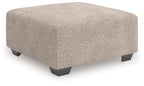 Beige oversized accent ottoman with square padded top and dark legs