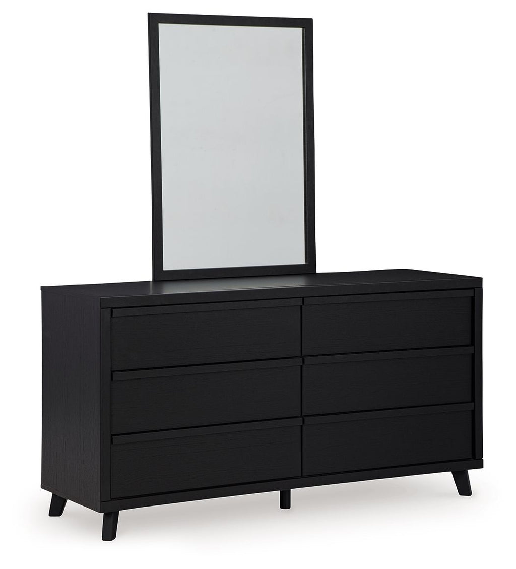 Black dresser with six drawer fronts and upright mirror, clean rectangular frame